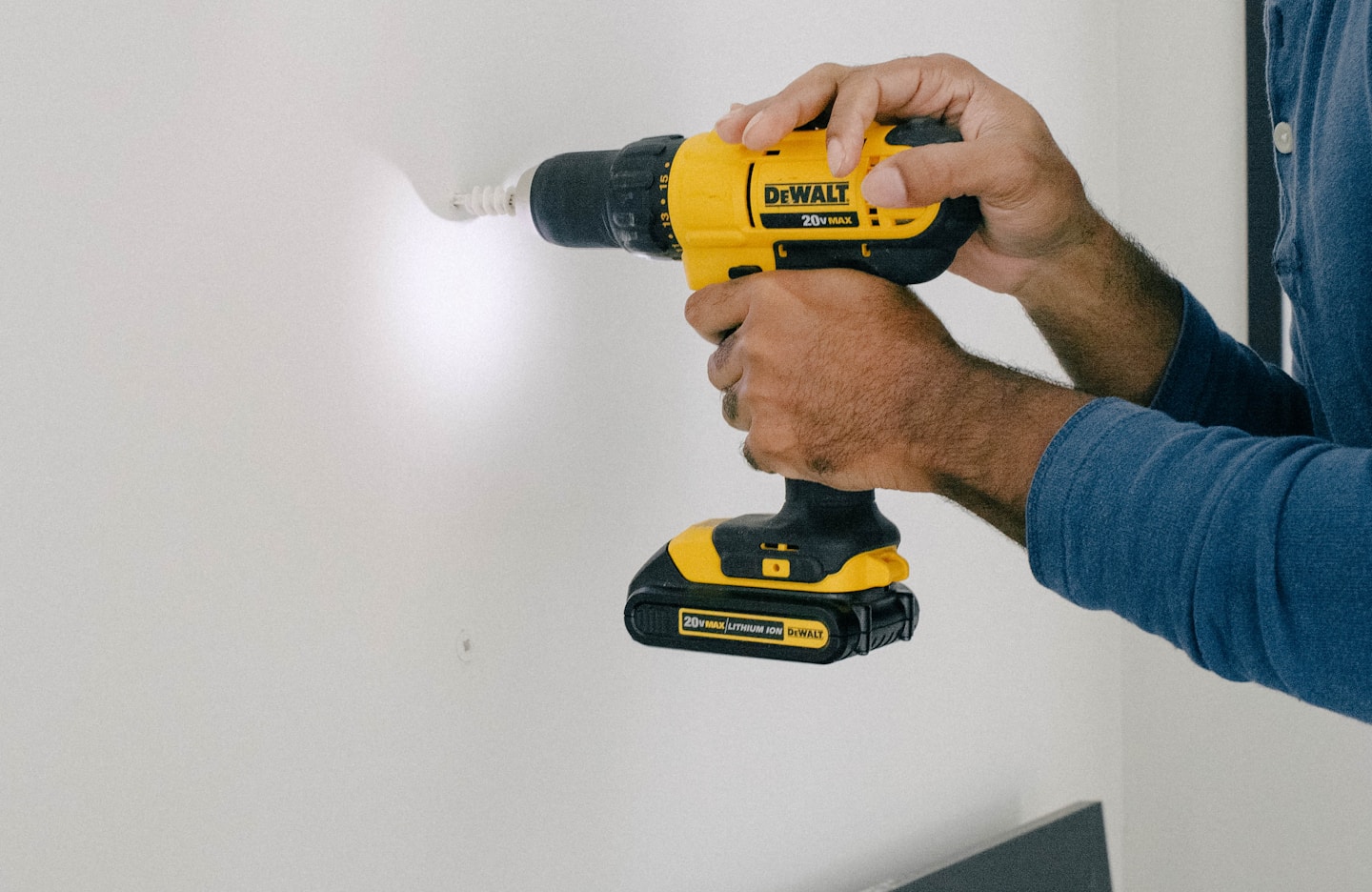 Hand holding a DeWalt cordless drill